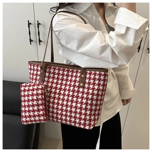 Detail view of large plaid tote bag with matching pouch on model in modern setting