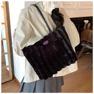 Detail of plush faux fur tote bag featuring vertical stripes and purple fashion girl patch