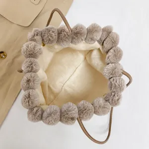 Top view of plush tote bag interior with soft lining and fuzzy pom-pom trim details