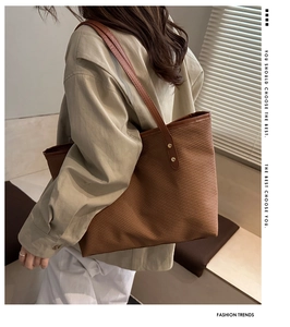 Detailed view of the brown textured tote bag with leather straps on a model shoulder