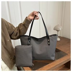 Detail of grey carbon fiber texture tote bag set with black handles and metal studs