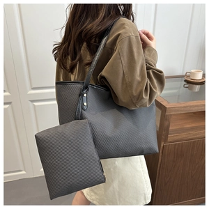 Detail of grey textured tote bag with small organizer pouch and gold hardware accents