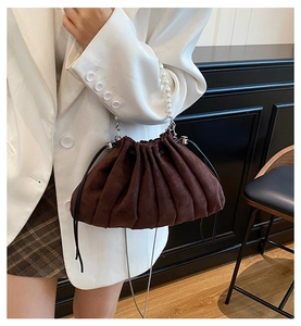 Detail of coffee brown pleated drawstring bag with pearl handle and metal chain strap
