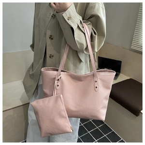 Pink tote bag with matching pouch showing fine twill texture and gold rivet details
