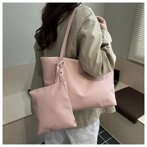 Detail of pink tote bag set with woven texture and matching pouch shown on a model