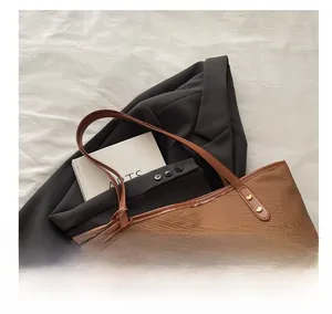 Close-up of woven texture and brown leather handle on a large commuter tote bag