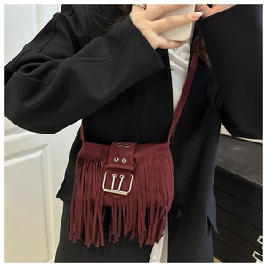 Detalle del bolso bandolera de ante burdeos con flecos vintage y hebilla de metal