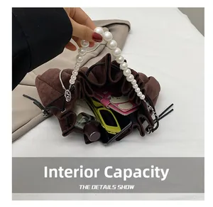 Internal capacity of brown suede bucket bag with pearls showing small daily items