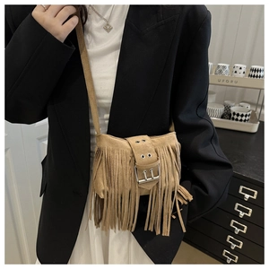 Gros plan d'un sac bandoulière en daim marron avec de longues franges et boucle argentée