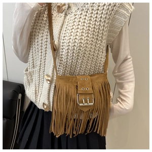 Détail du sac bandoulière en daim marron avec longues franges et boucle métallique