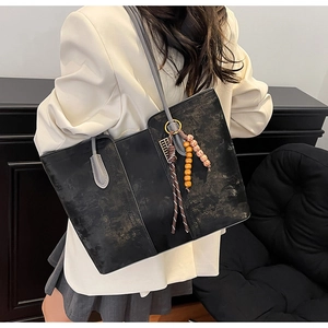 Chic retro tote bag with marble pattern texture and beaded tassels shown on a model