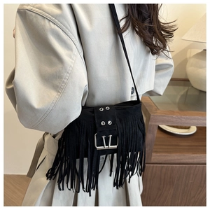 Detalle de bolso bandolera de ante negro con flecos y hebilla metálica plateada
