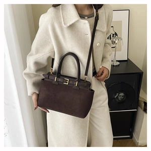 Detail of vintage chocolate brown suede tote bag with adjustable strap and gold hardware