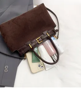 Detail view of brown suede tote bag interior showing capacity for phone and cosmetics