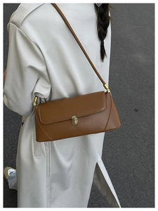 Photo street style d'un sac baguette en cuir marron avec un fermoir en métal rétro