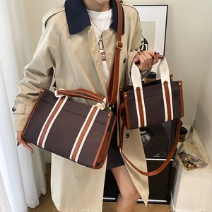 Large and small canvas tote bags in dark brown and white with leather handles and straps