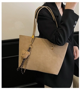 Détail du grand sac cabas en cuir givré kaki avec fines lanières et pendentif ours mignon
