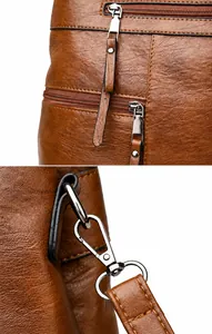 Detail of dual zipper closures and dark grey metal hardware on brown lychee leather bag