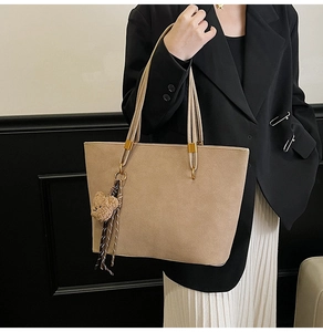 Sac cabas kaki givré porté par mannequin avec bandoulière et pendentif ours de mode