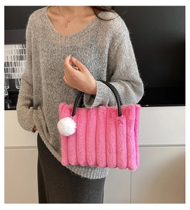 Detail of pink plush tote bag with vertical stripes and black woven handles