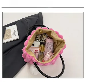 Spacious interior of pink faux fur tote bag holding a phone, umbrella and cosmetics