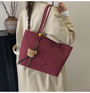 Sac fourre-tout vintage rouge foncé avec ours en peluche porté par un mannequin