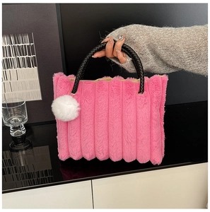 Detailed close-up of pink faux fur tote bag with black woven handle and cute white pompom