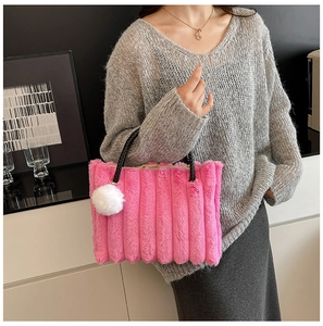 Detail of fuchsia faux fur tote bag with vertical quilting and black woven handles