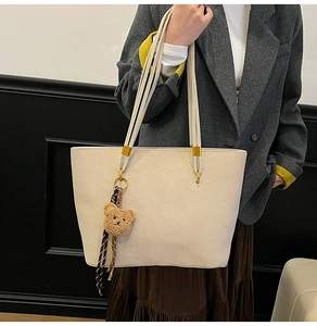Détail du grand sac cabas blanc cassé avec doubles fines lanières et charm ours marron