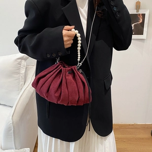 Pleated burgundy velvet drawstring bucket bag with pearl handle and metal strap