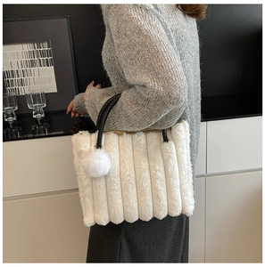Close-up of white plush tote bag with vertical stripes and black textured top handle