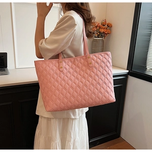 Side view of pink quilted leather tote bag worn as a shoulder bag showing large capacity