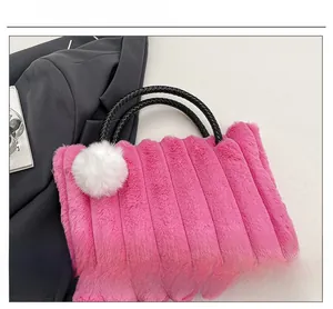 Detail of rose red plush tote with striped faux fur texture and white pom-pom charm