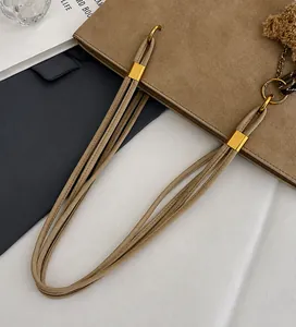 Détail du sac cabas en daim beige avec longues anses et breloque ours en peluche