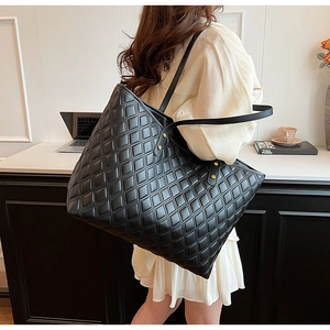 Close-up of black quilted tote bag with gold rivets and spacious interior for daily commute