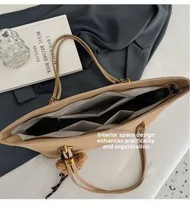 Design intérieur du cabas en daim beige avec poches zippées et boucles métalliques