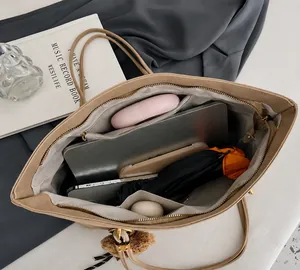 Vue intérieure d'un grand sac fourre-tout kaki avec rangement pour ordinateur et objets
