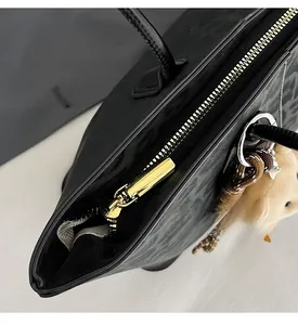 Macro shot of the smooth gold metal zipper and leopard pattern texture on the tote bag