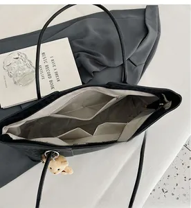 Detailed interior of large black tote bag showing zipper pockets and spacious layout