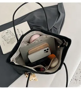 Macro shot showing large storage capacity of black tote bag with multiple inner pockets
