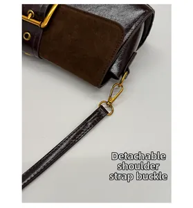 Detail of detachable shoulder strap hook on brown matte leather baguette bag