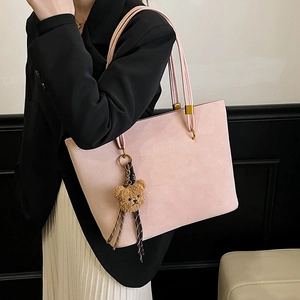 Grand sac cabas rose mat avec pendentif ourson porté à l'épaule par un mannequin