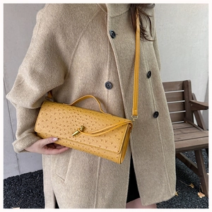 Chic yellow ostrich pattern baguette bag with metal latch lock worn crossbody outdoor