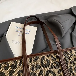 Detail van de luipaard tote bag met bruine leren riemen en nauwkeurige stiksels