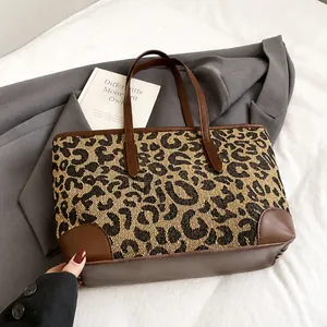 Detail van de canvas shopper met luipaardprint voorzien van bruin lederen bies en handgreep