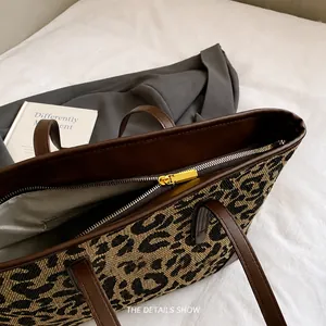 Detailopname van de gouden rits en luipaardprint op een stijlvolle shopper van textiel