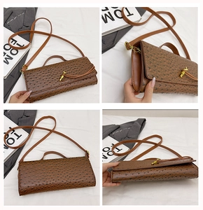 Detailed close-up of brown ostrich texture leather bag with vintage gold turn-lock closure