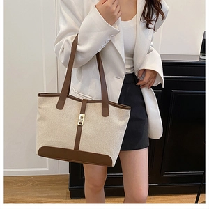 Vue détaillée du sac en toile avec garniture en cuir marron et fermoir doré chic