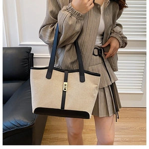 Détail du sac cabas en toile avec garniture en cuir contrasté et fermoir en métal doré