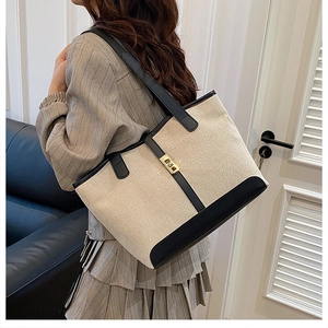 Détail du sac cabas en toile avec garniture en cuir noir et boucle dorée chic